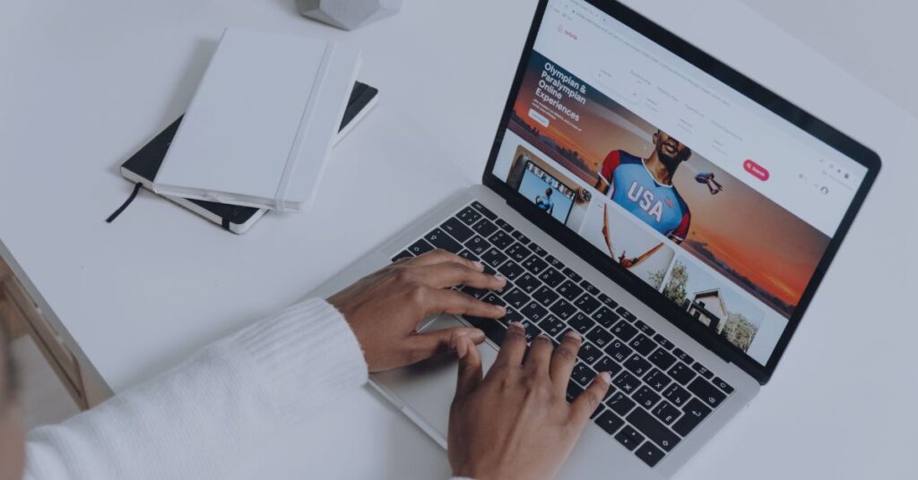 Henkilö tekemässä Google-hakua kannettavalla tietokoneella työpöydän ääressä