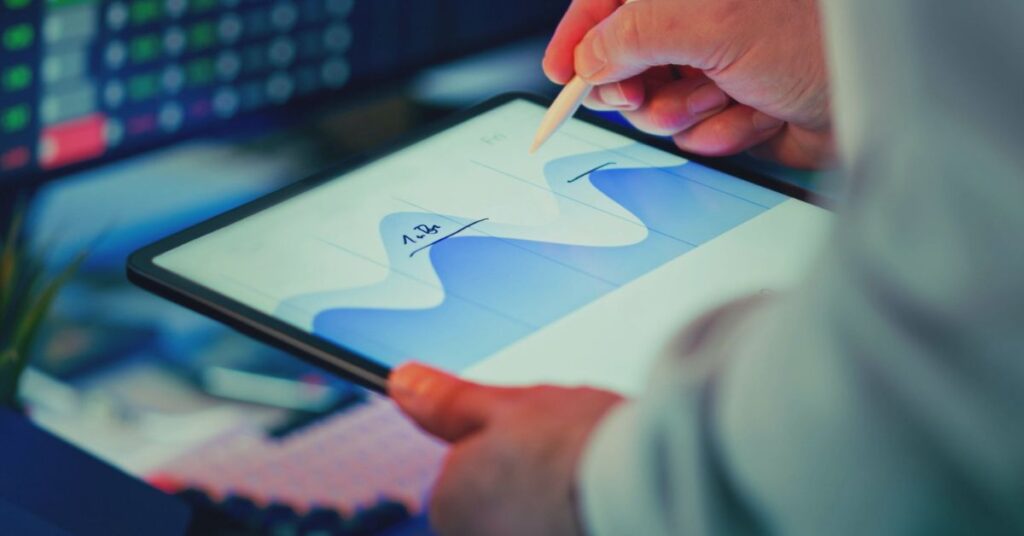 Johtaja tarkastelee laatu- ja ympäristöjohtamisen mittareita digitaaliselta näytöltä.
